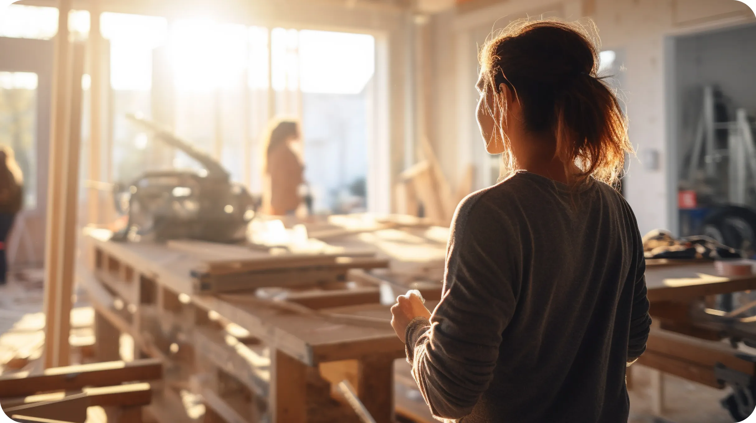 A woman looking at a workers in a carpenter workshop