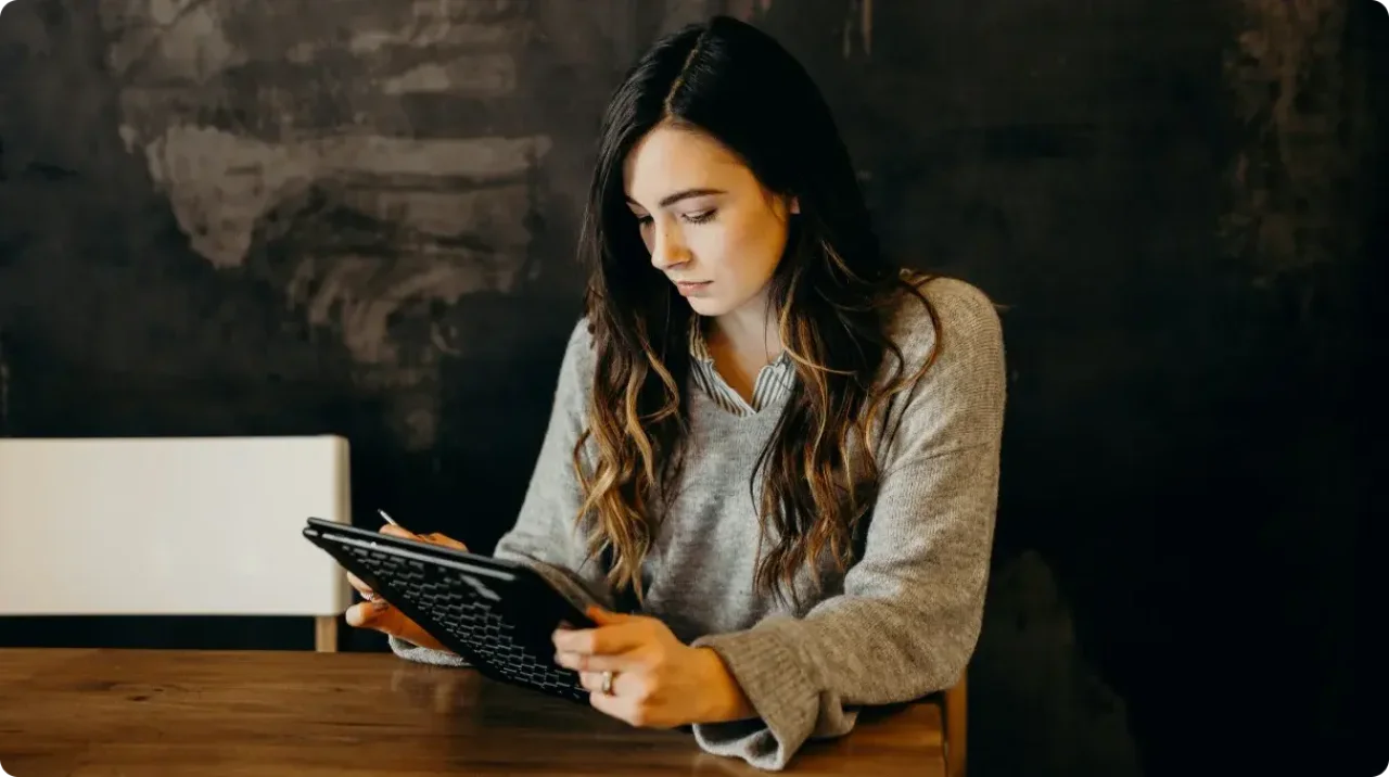 A woman working on a tablet.