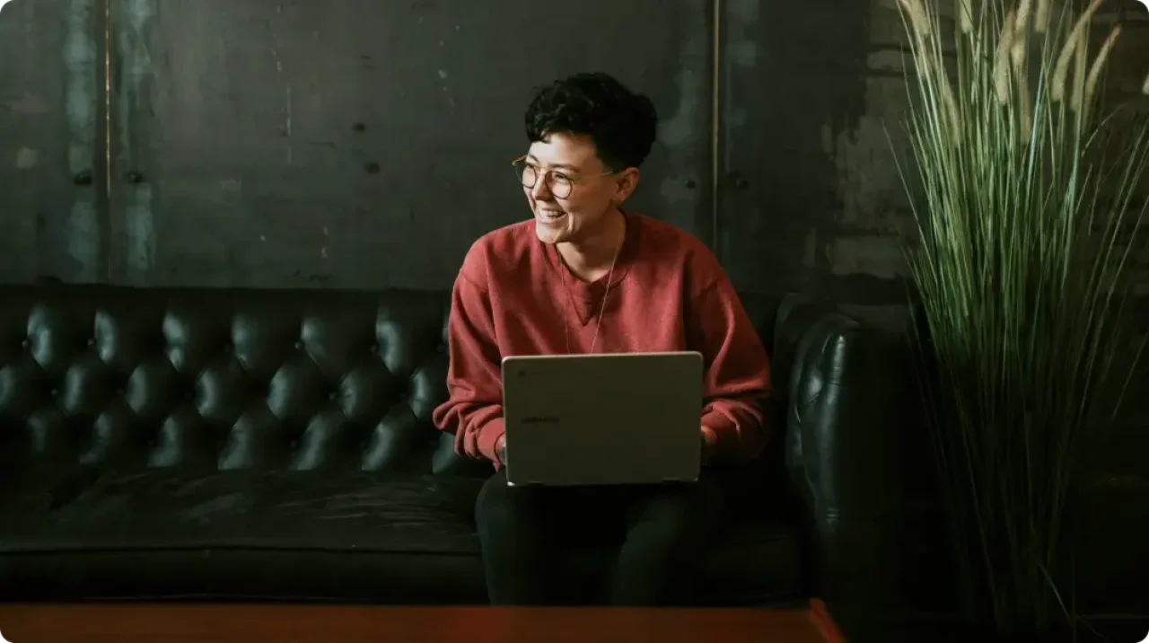 A men sitting on a coach using a laptop