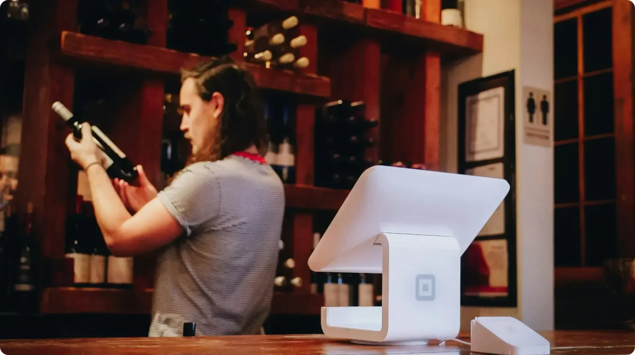 A lady looking at a bottle of wine.