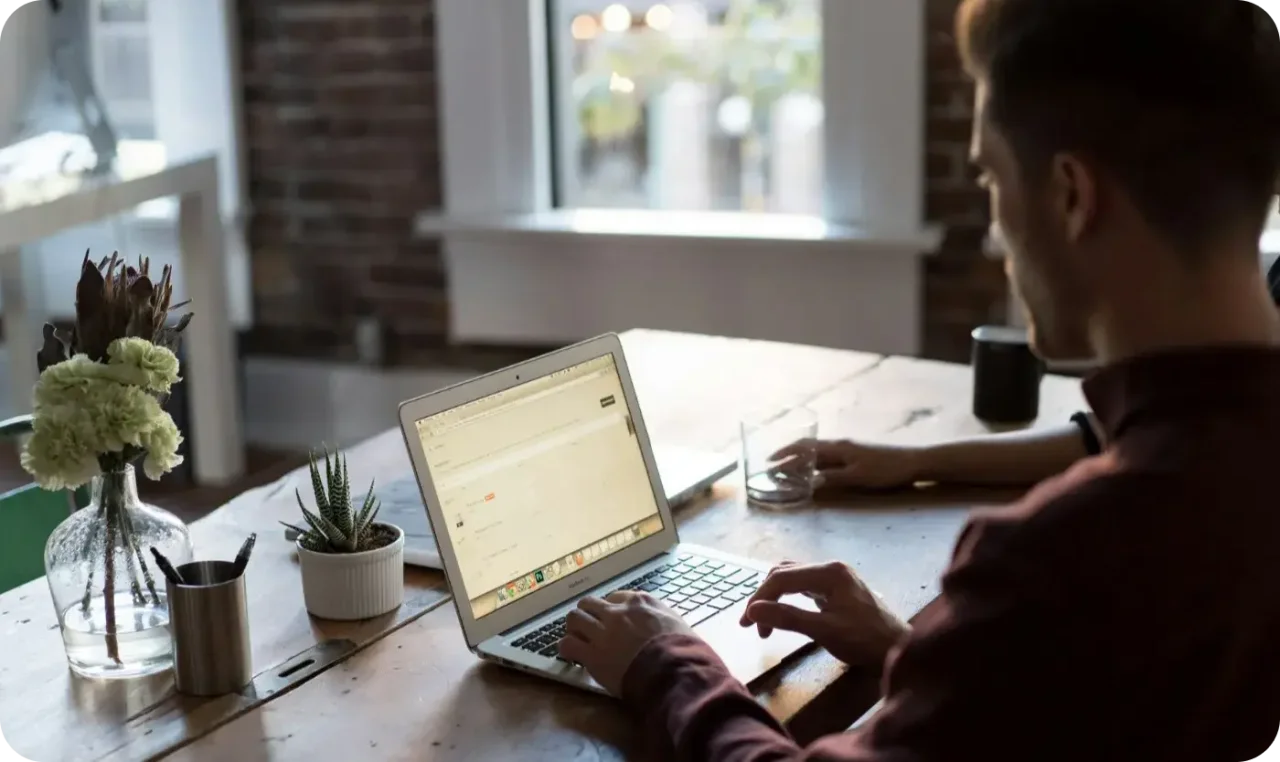 Man Working On Laptop At Home Office Desk