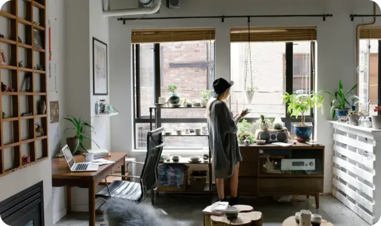 A woman in a office, standing and tapping something on a tablet