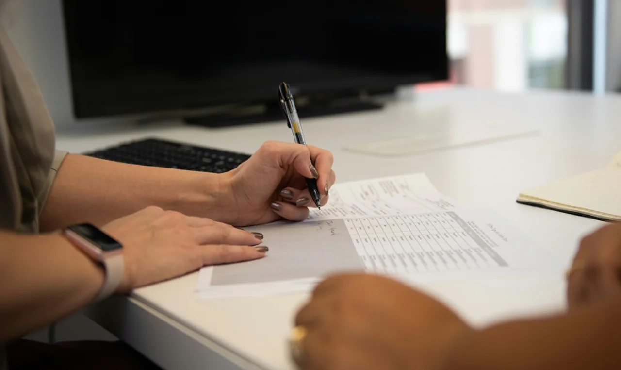 Entrepreneur reviewing a contract at a desk with warning symbols and documents labeled 'Legal Issues' and 'Missed Terms'—representing costly legal mistakes made after reaching $100K in sales.