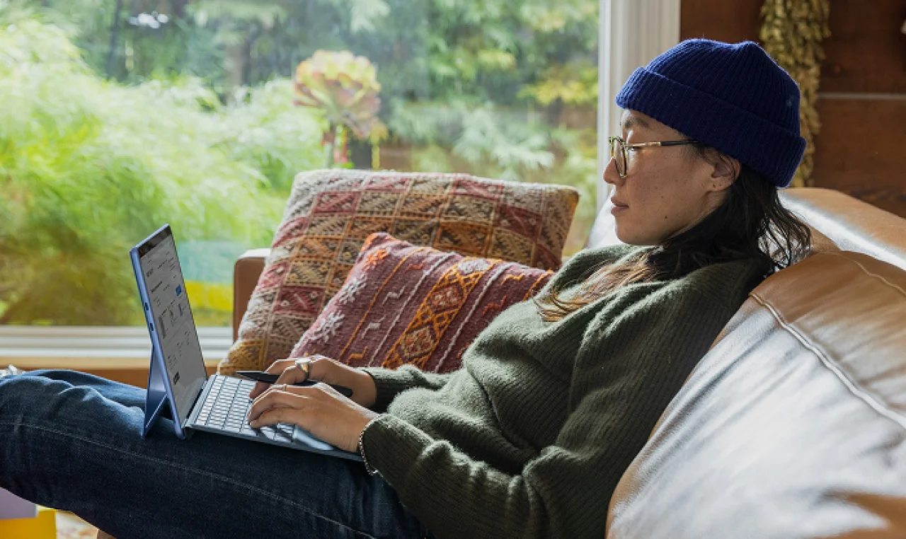 Solo entrepreneur working late at a kitchen table with a laptop, coffee, and legal paperwork spread out