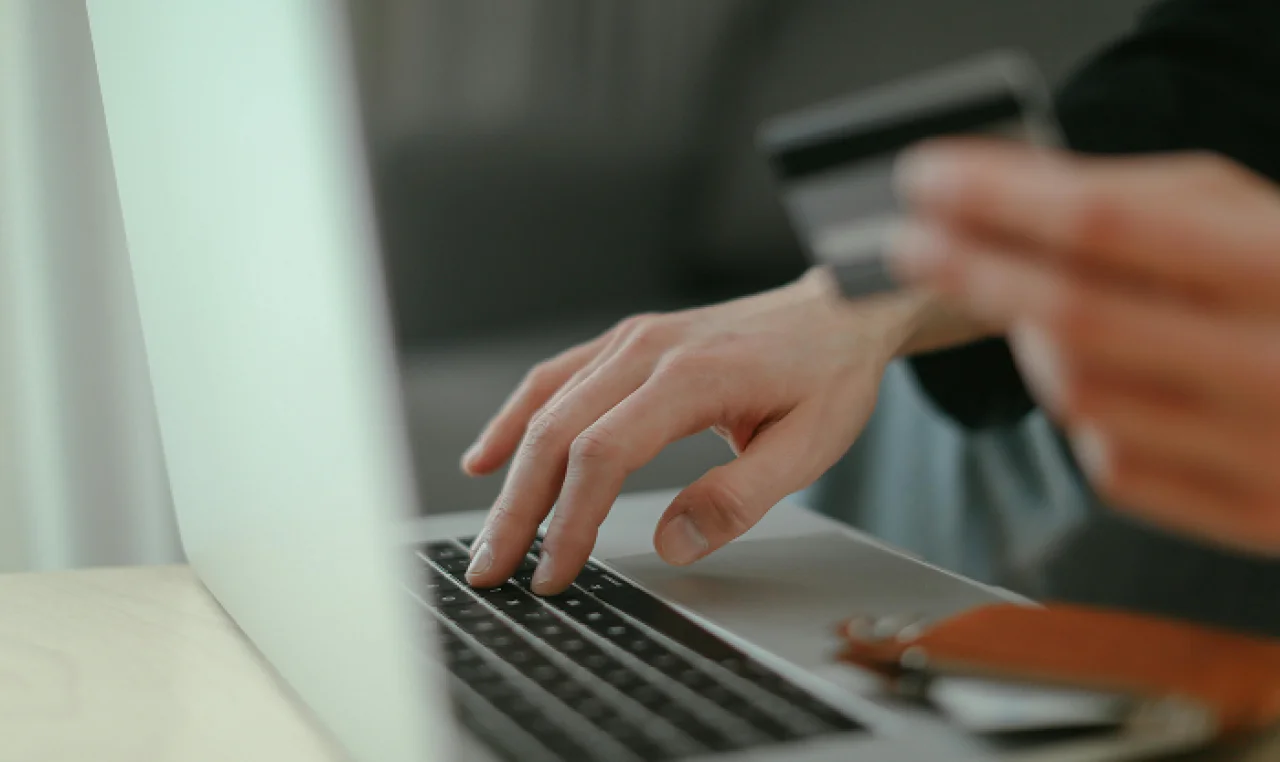 Person making an online payment using a credit card and laptop for secure digital transactions.